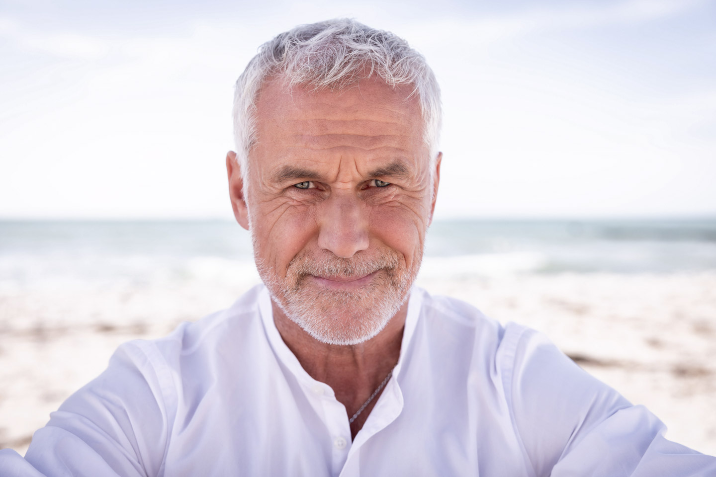 Portrait Headshot älterer Mann mit weissem Hemd am Strand