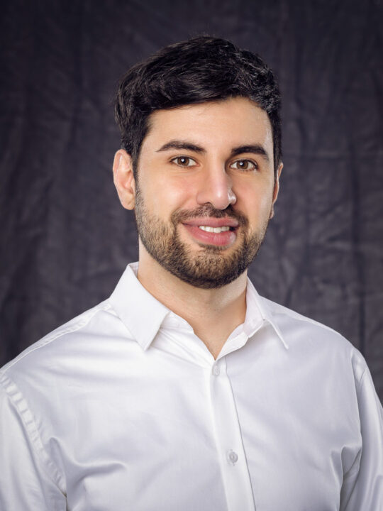 Brust Portrait eines jungen Mannes vor schwarzem Hintergrund